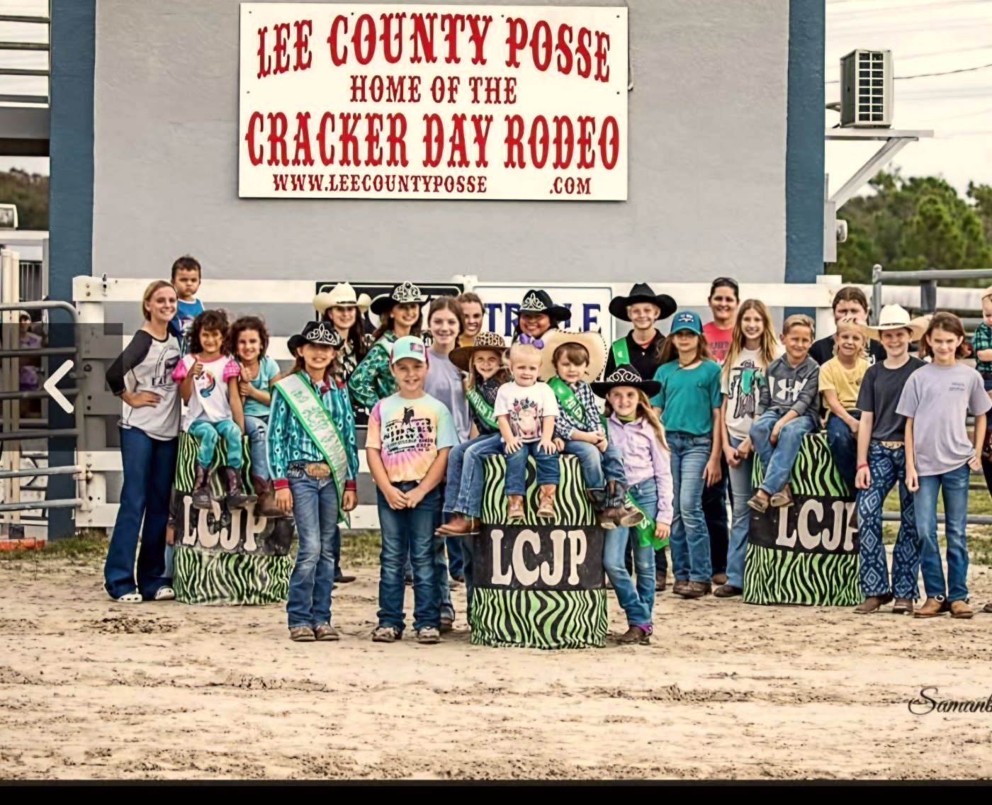 Junior Posse members beneath the Home of the Cracker Day Rodeo sign